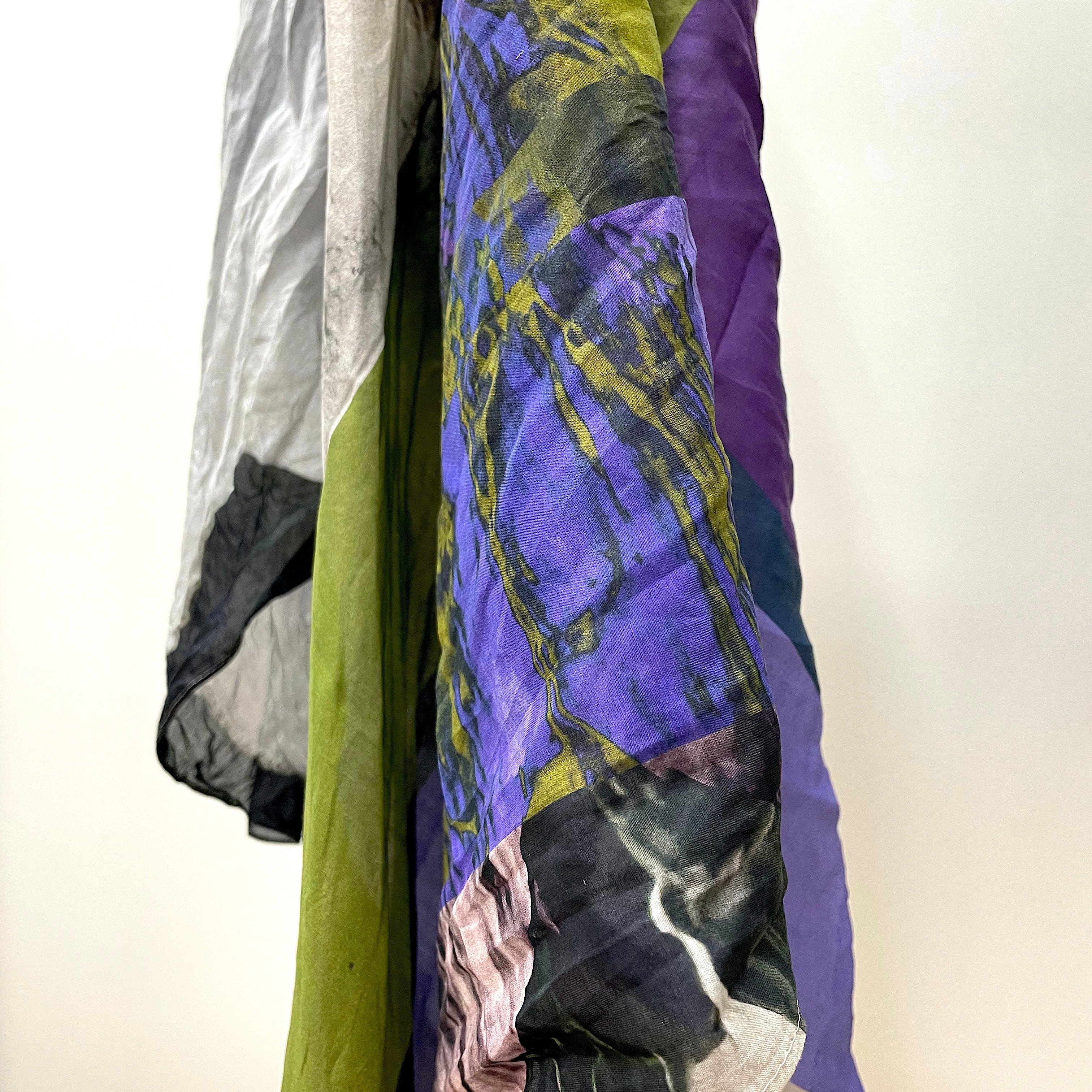 digital print pattern on silk fabric. abstract pattern on light greay base colour with highlights of pink, bright purple, bright olive green and black