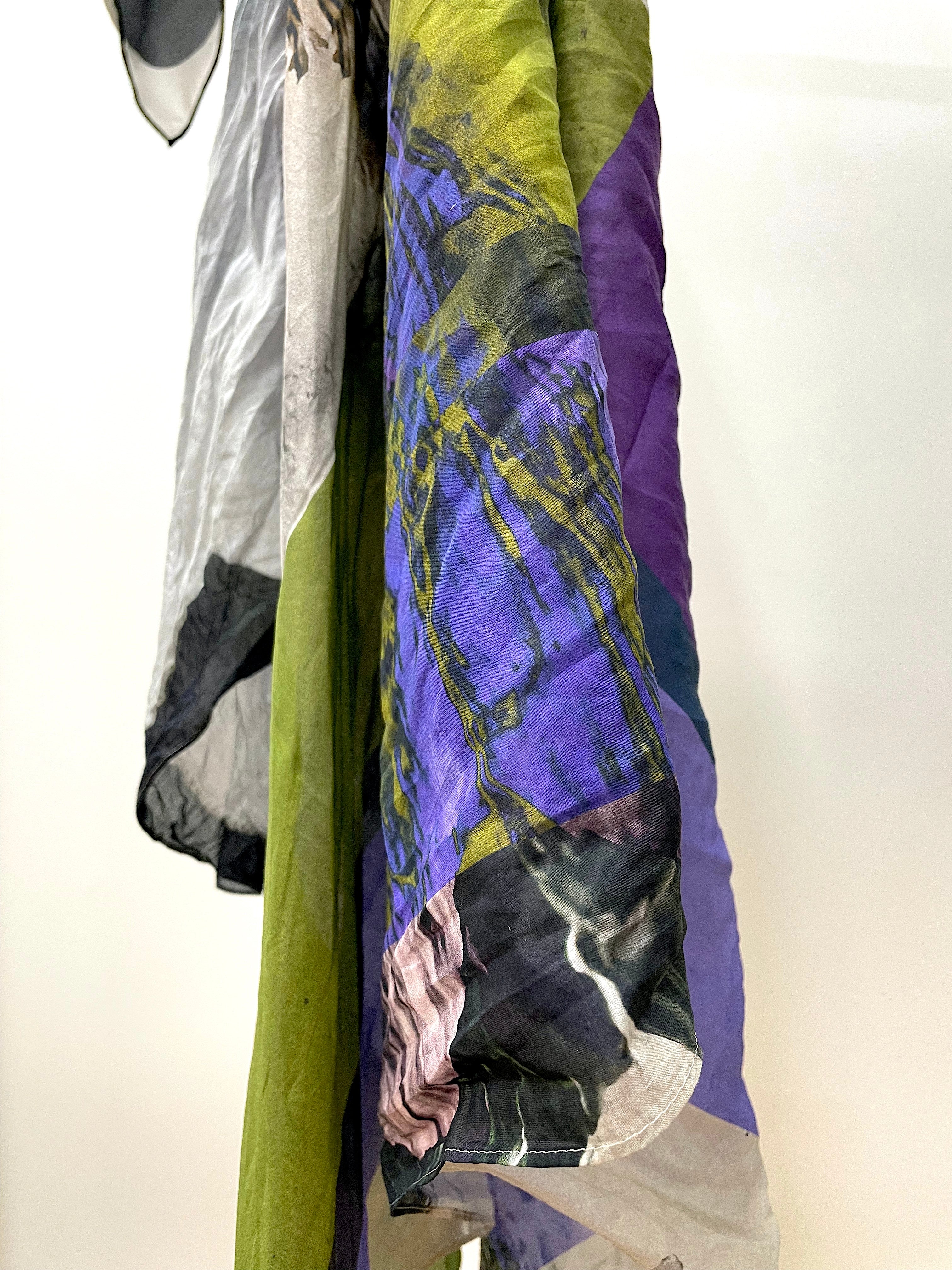 digital print pattern on silk fabric. abstract pattern on light greay base colour with highlights of pink, bright purple, bright olive green and black